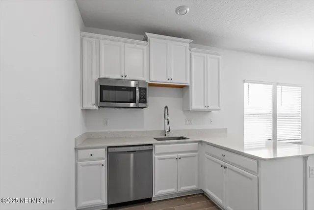 a kitchen with white cabinets and a sink