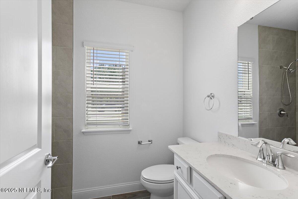 21 Pine Candle Way St. Augustine, FL 32092 - Photo 23 of 35 a bathroom with a granite countertop sink toilet a mirror and shower