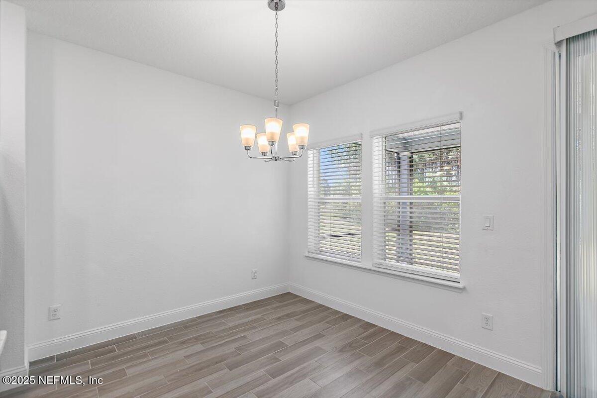21 Pine Candle Way St. Augustine, FL 32092 - Photo 6 of 35 a view of an empty room with wooden floor and a window