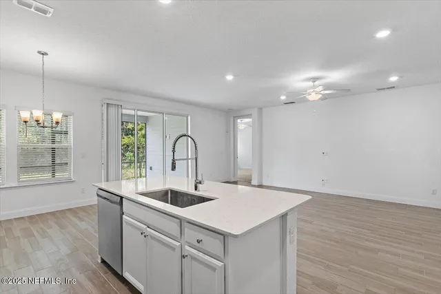 a kitchen with a sink cabinets and wooden floor