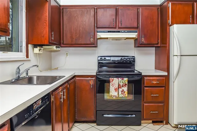 a view of an empty room with wooden floor fireplace and a window