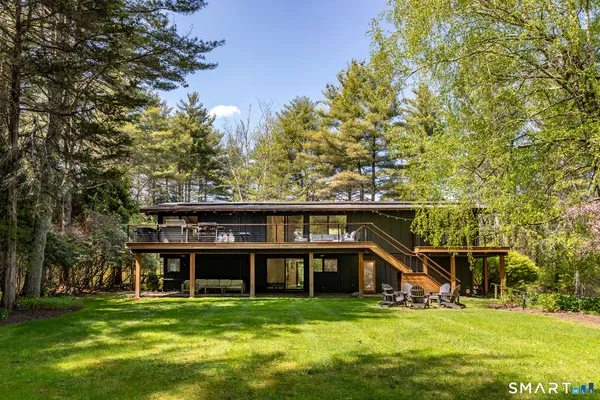 a view of a house with a big yard and large trees