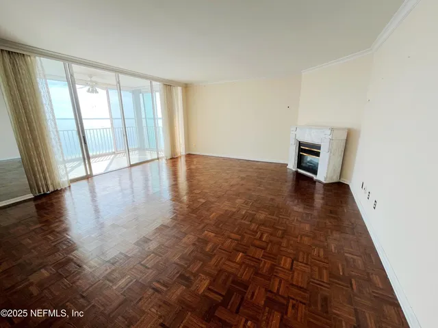 a view of a hallway with wooden floor and fireplace