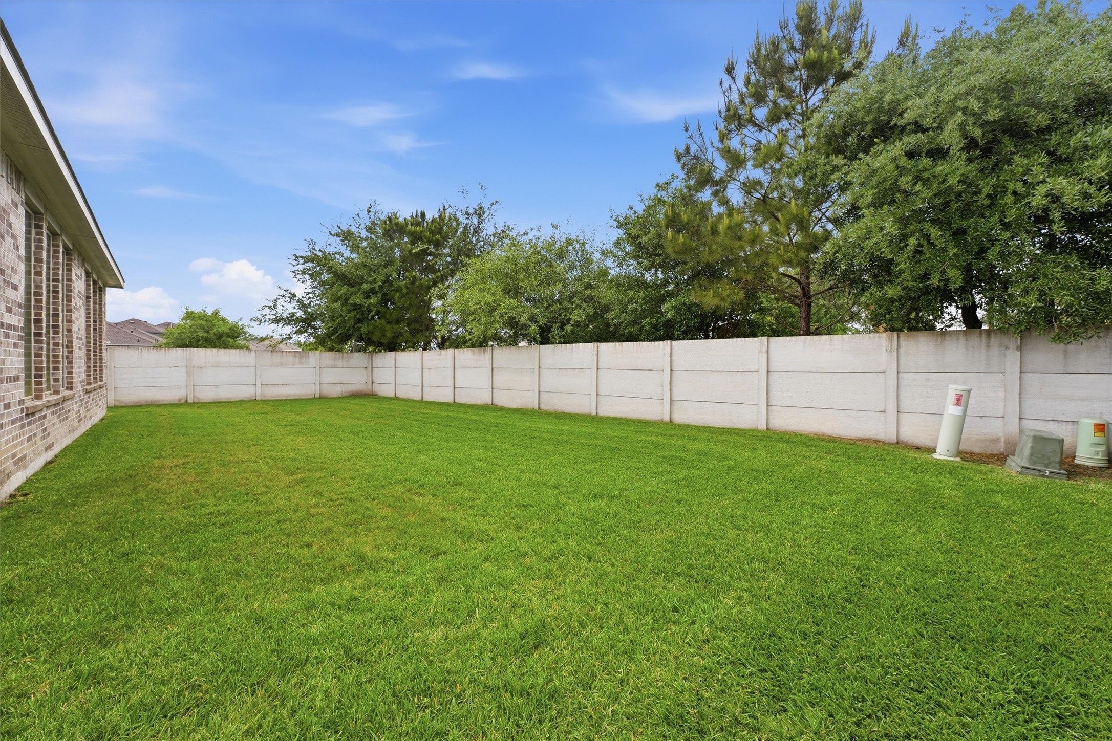 6071 Windward Falls Way Porter, TX 77365 - Photo 25 of 33 Spacious backyard with a well-maintained lawn, bordered by a privacy fence. Ideal for outdoor activities and gardening.
