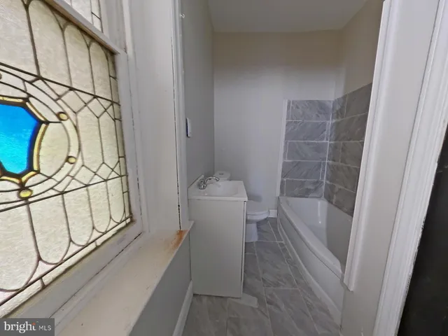 a bathroom with a bathtub a mirror a sink and vanity