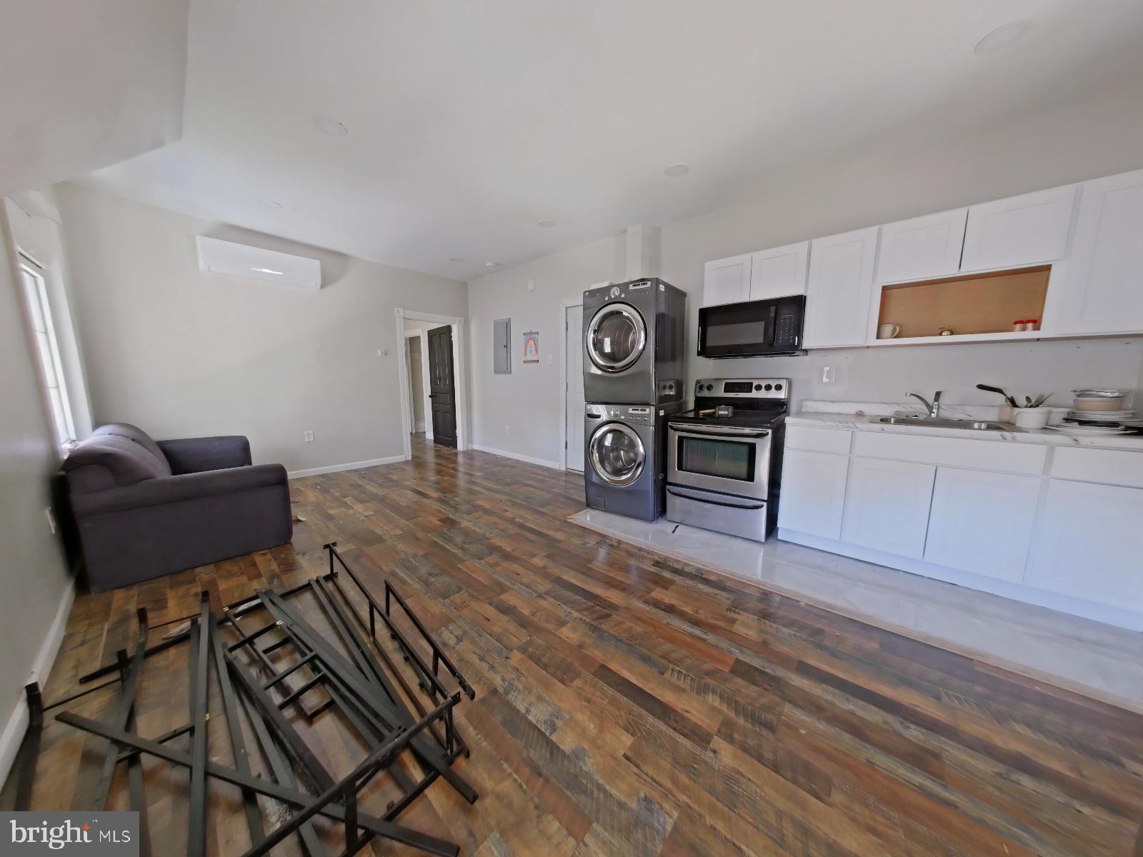 5331 Wayne Avenue Philadelphia, PA 19144 - Photo 38 of 53 a living room with furniture a flat screen tv and kitchen view