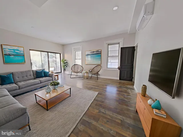 a living room with furniture a flat screen tv and a large window