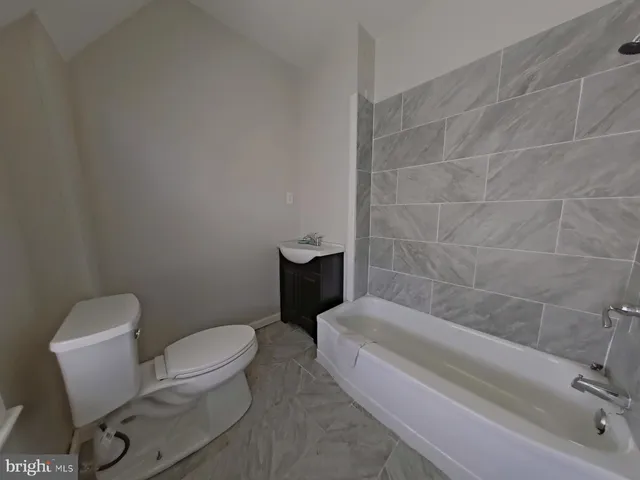 a view of empty room with window and wooden floor