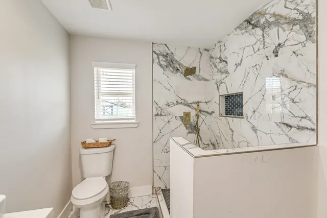 a white toilet sitting next to a bathroom sink