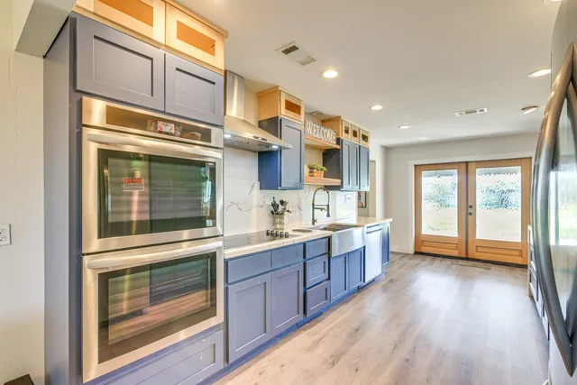 a large kitchen with stainless steel appliances granite countertop a stove and a sink