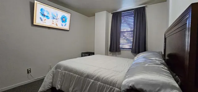 a bedroom with a bed and a painting on the wall