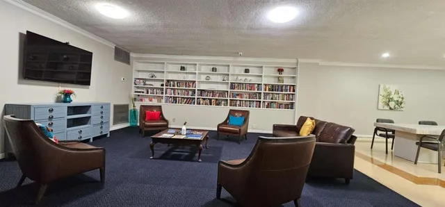 a work room with furniture a flat screen tv and gym equipment