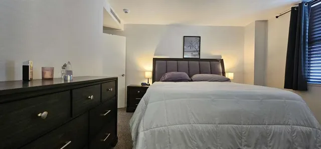 a bedroom with a bed and a night stand