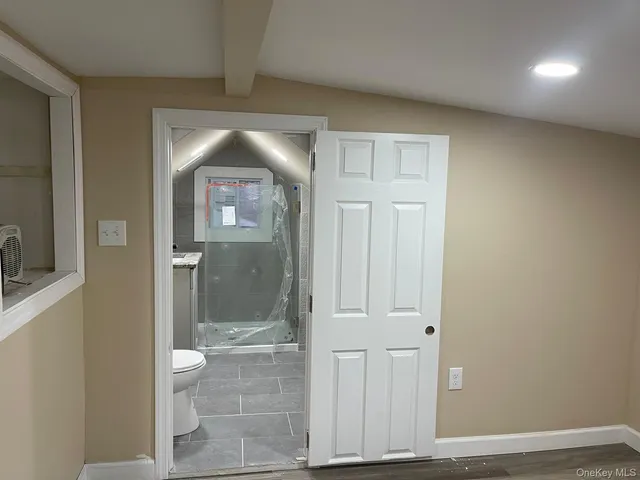 a view of a bathroom with mirror and shower