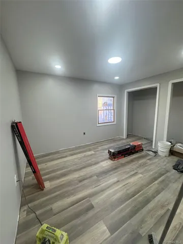 a view of a room with gym equipment and wooden floor