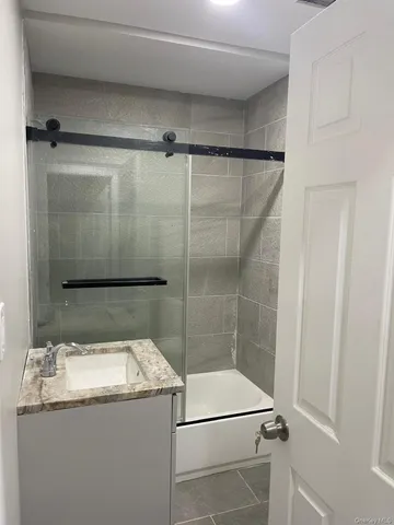 a bathroom with a granite countertop sink mirror and shower