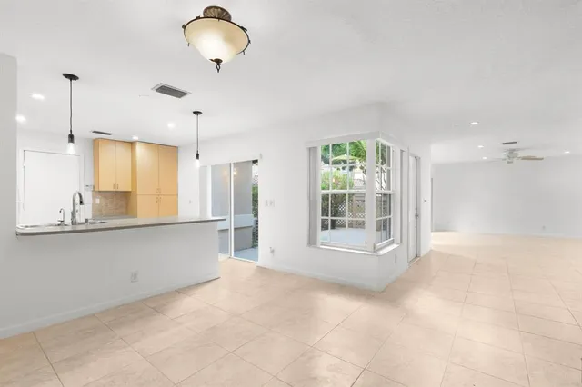 an empty room with a window and a ceiling fan