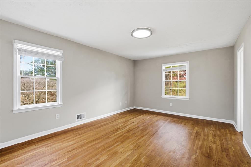 127 Old Rosser Road Lilburn, GA 30047 - Photo 14 of 34 an empty room with wooden floor and windows