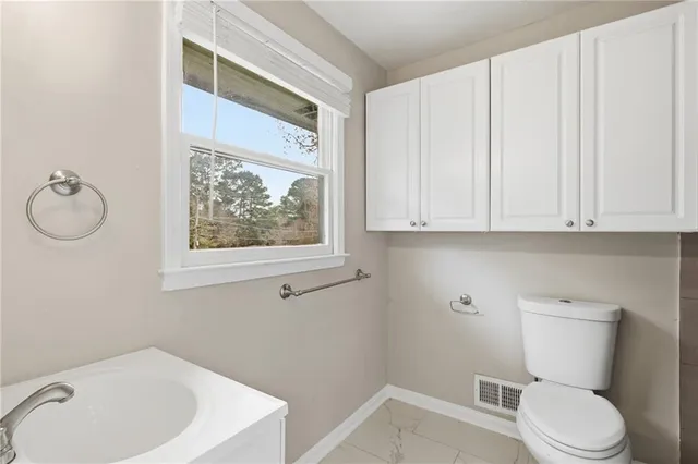 a white toilet sitting next to a bathroom sink