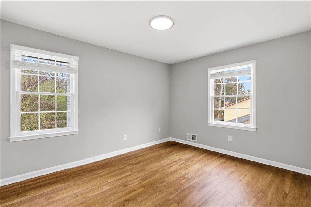 127 Old Rosser Road Lilburn, GA 30047 - Photo 16 of 34 an empty room with wooden floor and windows