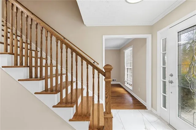 a view of staircase with railing and a rug
