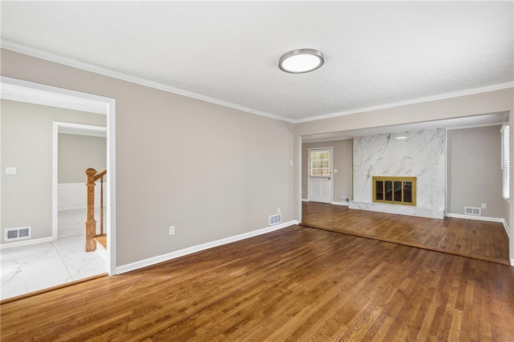 127 Old Rosser Road Lilburn, GA 30047 - Photo 5 of 34 a view of an empty room with wooden floor and a window