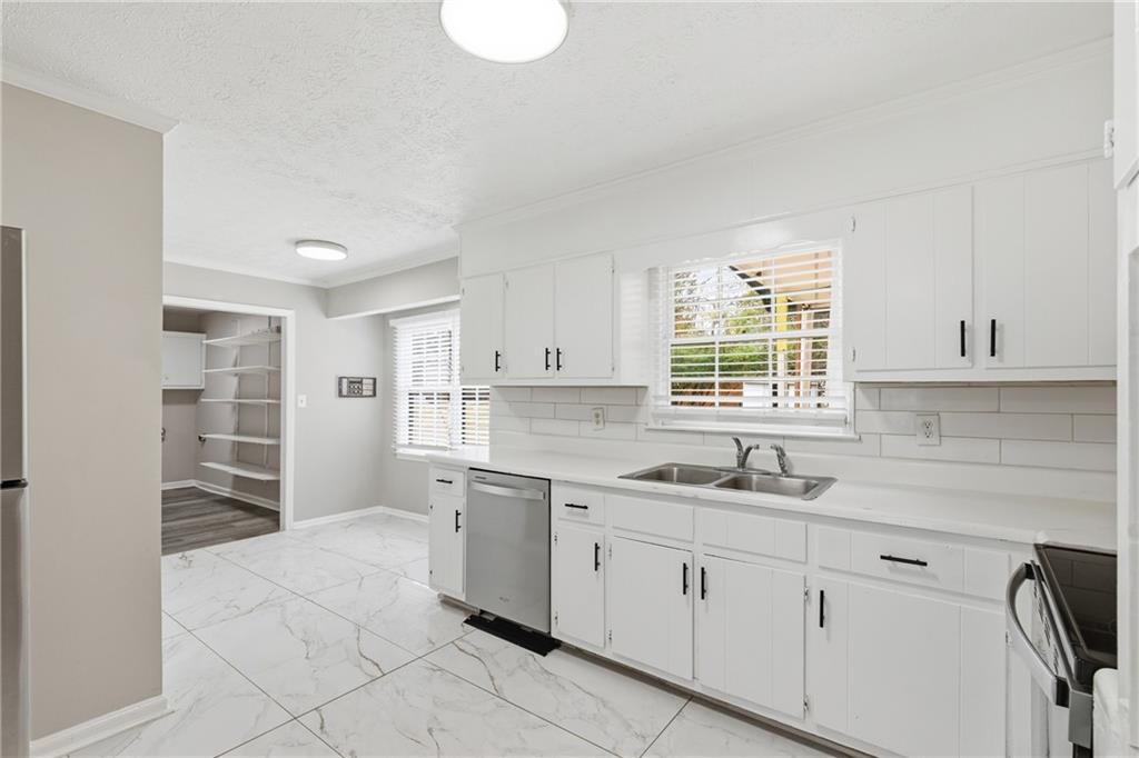 127 Old Rosser Road Lilburn, GA 30047 - Photo 8 of 34 a kitchen with a sink cabinets and window