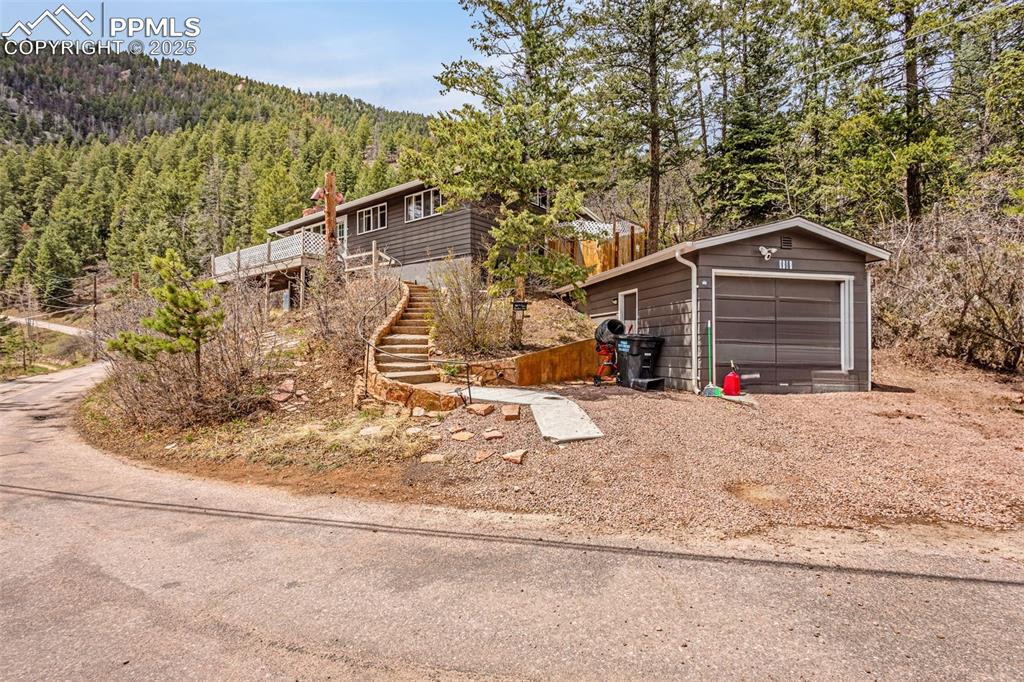 9515 Mountain Road Cascade, CO 80809 - Photo 2 of 34 a front view of a house with a yard and garage