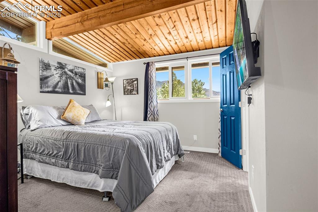 9515 Mountain Road Cascade, CO 80809 - Photo 21 of 34 a bedroom with a bed next to a window