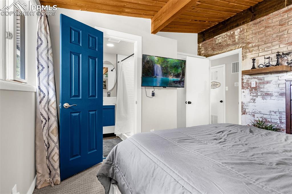 9515 Mountain Road Cascade, CO 80809 - Photo 22 of 34 a bedroom with a bed a flat screen tv and a fireplace