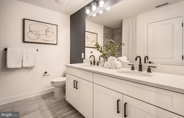 a bathroom with a toilet a sink and mirror