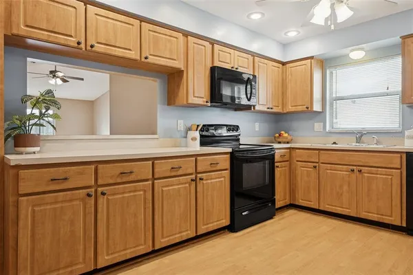 a kitchen with cabinets appliances a sink and a counter top space