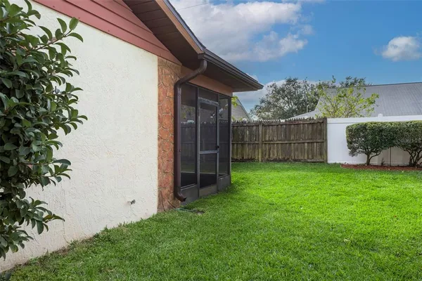 a view of a backyard with plants and wooden fence