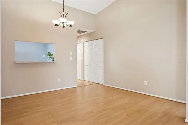 a view of an empty room with a chandelier fan