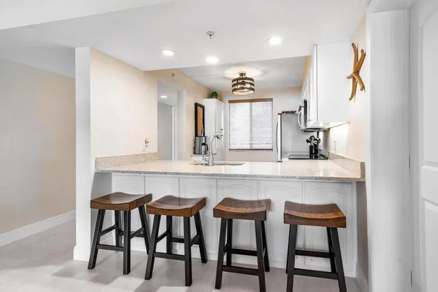 a kitchen with a table chairs sink and cabinets