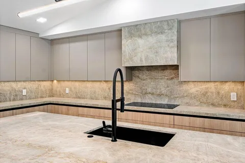 a view of a kitchen with a sink and large window