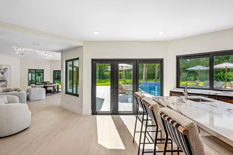 a living room with furniture fireplace and large windows