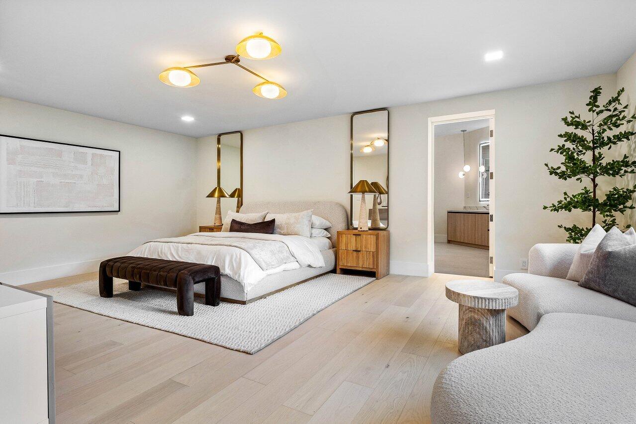 8090 Twin Lake Drive Boca Raton, FL 33496 - Photo 36 of 56 a spacious bedroom with a bed and a chandelier