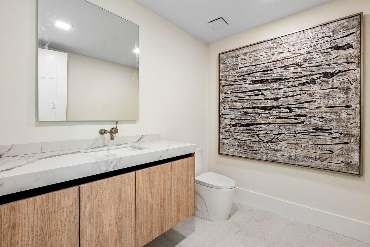 8090 Twin Lake Drive Boca Raton, FL 33496 - Photo 48 of 56 a bathroom with a granite countertop sink a toilet and a shower