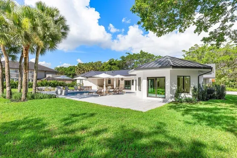 an aerial view of a house with a garden and lake view