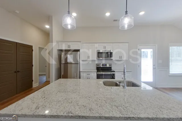a kitchen with kitchen island a sink appliances and cabinets