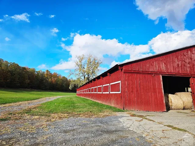 a view of a house with pool and trees in the background
