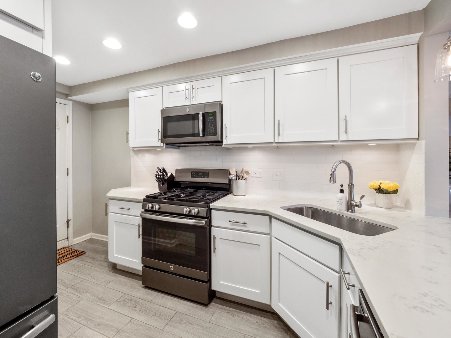 2439 North Burling Street, Unit G Chicago, IL 60614 - Photo 4 of 20 a kitchen with white cabinets stainless steel appliances and sink
