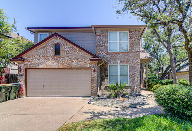7712 Earp Way Austin, TX 78729 - Photo 1 of 37 a front view of a house with a garden and garage