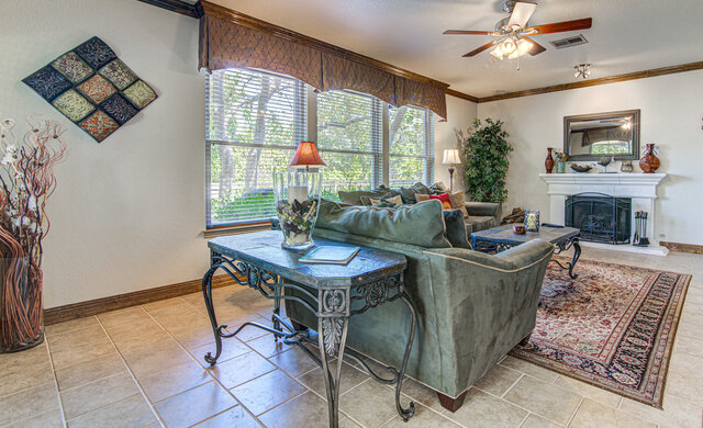 7712 Earp Way Austin, TX 78729 - Photo 11 of 37 a living room with furniture a chandelier and a fireplace