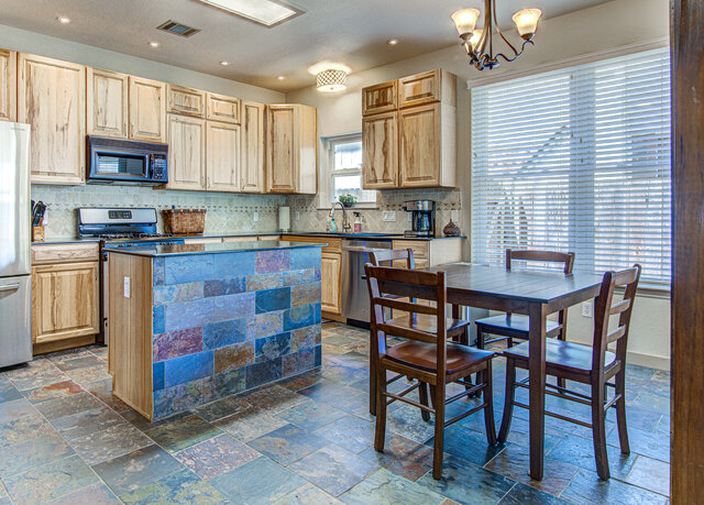 7712 Earp Way Austin, TX 78729 - Photo 14 of 37 a kitchen with a table chairs microwave and cabinets