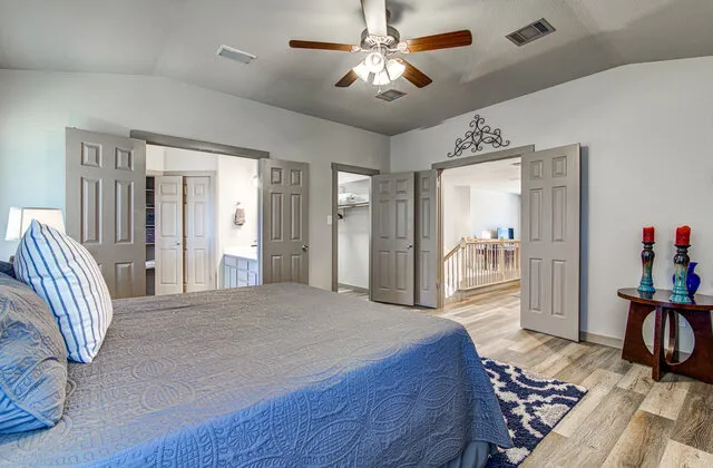 a spacious bedroom with a bed and a chandelier