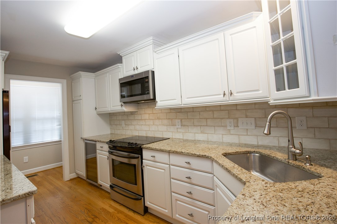 175 Knoll Road Southern Pines, NC 28387 - Photo 7 of 50 a kitchen with granite countertop a sink a stove and microwave