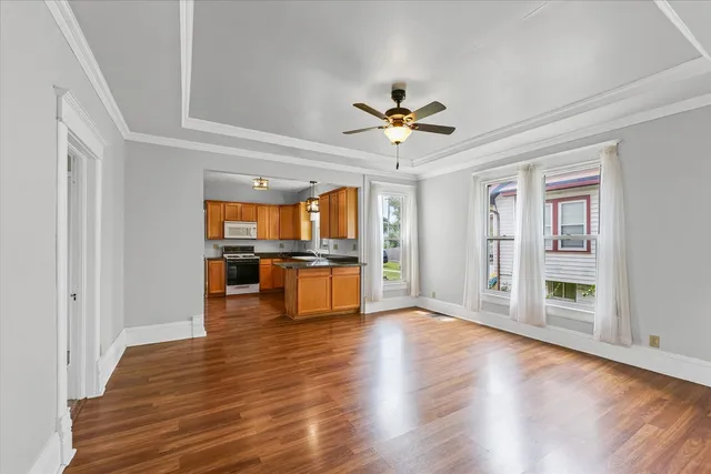 a view of an empty room with window and wooden floor
