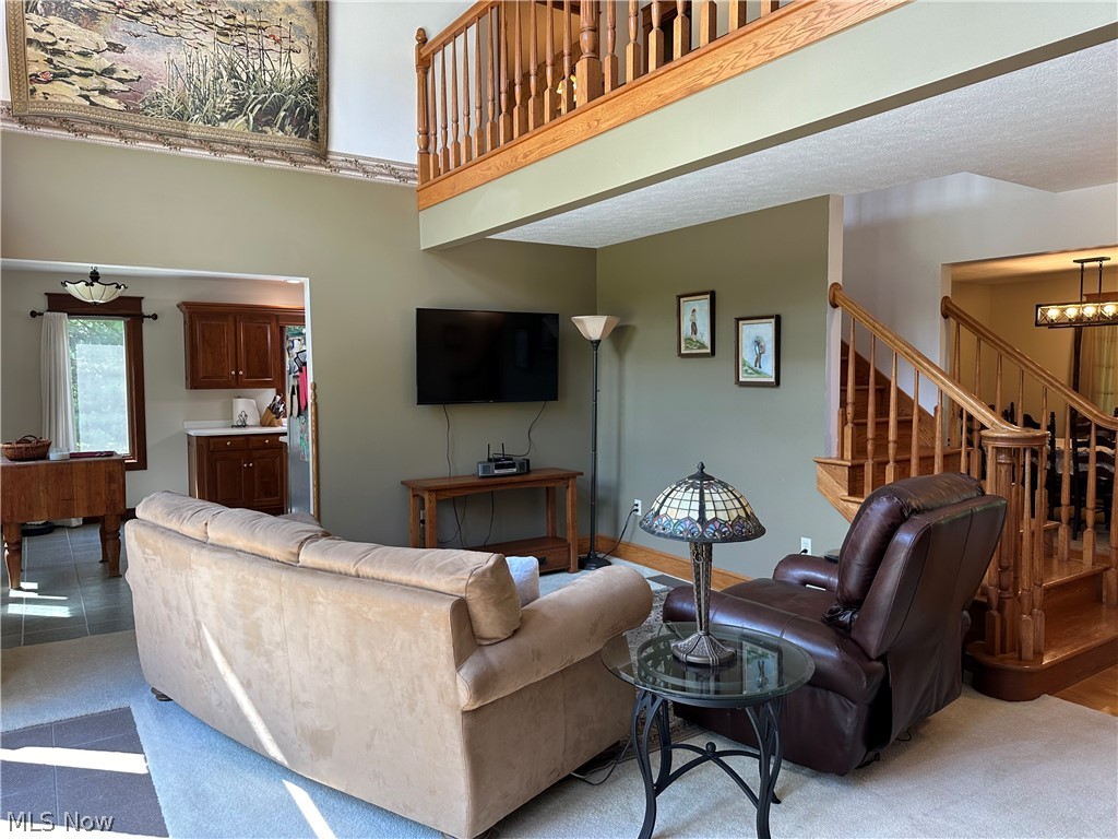 5233 Secrest Road Wooster, OH 44691 - Photo 31 of 33 Carpeted living room featuring an inviting chandelier and a high ceiling